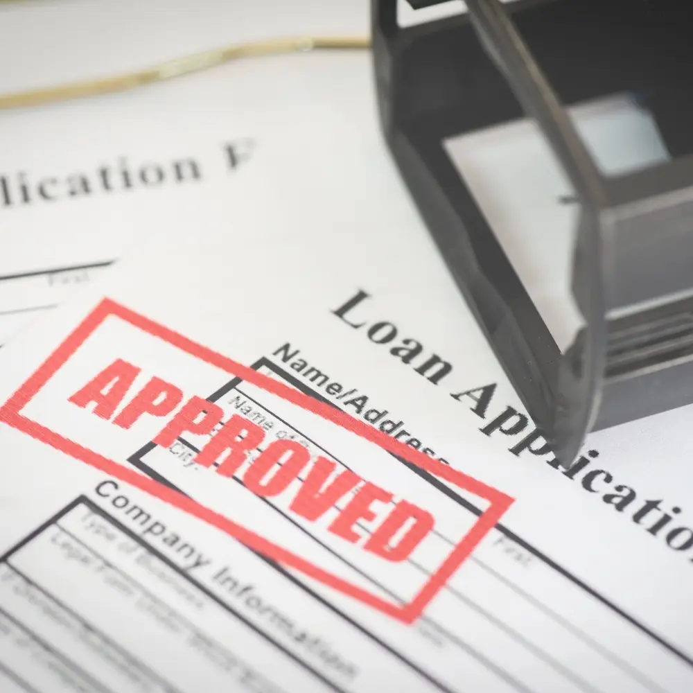 A loan application form for home loans stamped APPROVED, with a black ink stamp nearby—ideal for first-time home buyers.