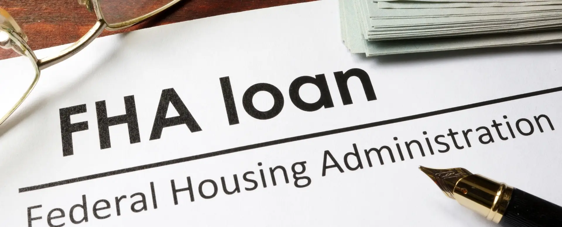 A document titled FHA loan Federal Housing Administration next to a pen, glasses, and mortgage refinance papers.