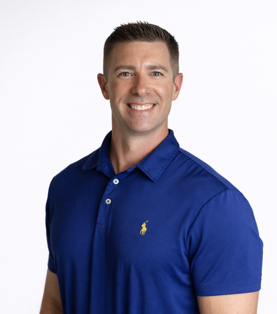 Smiling mortgage lender in a blue polo shirt stands against a plain white background.
