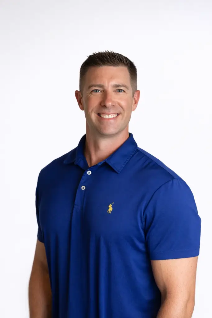Smiling man in a blue polo shirt standing against a white background, ideal for first-time home buyers content.
