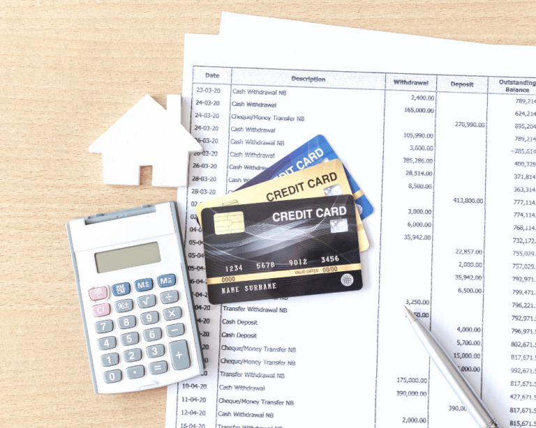 Three credit cards, a calculator, and financial statements on a desk, hinting at home loans for first-time home buyers.