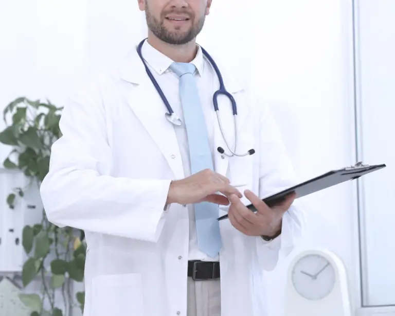 Male doctor in a white coat with a clipboard, like a mortgage lender guiding first-time home buyers in his bright office.