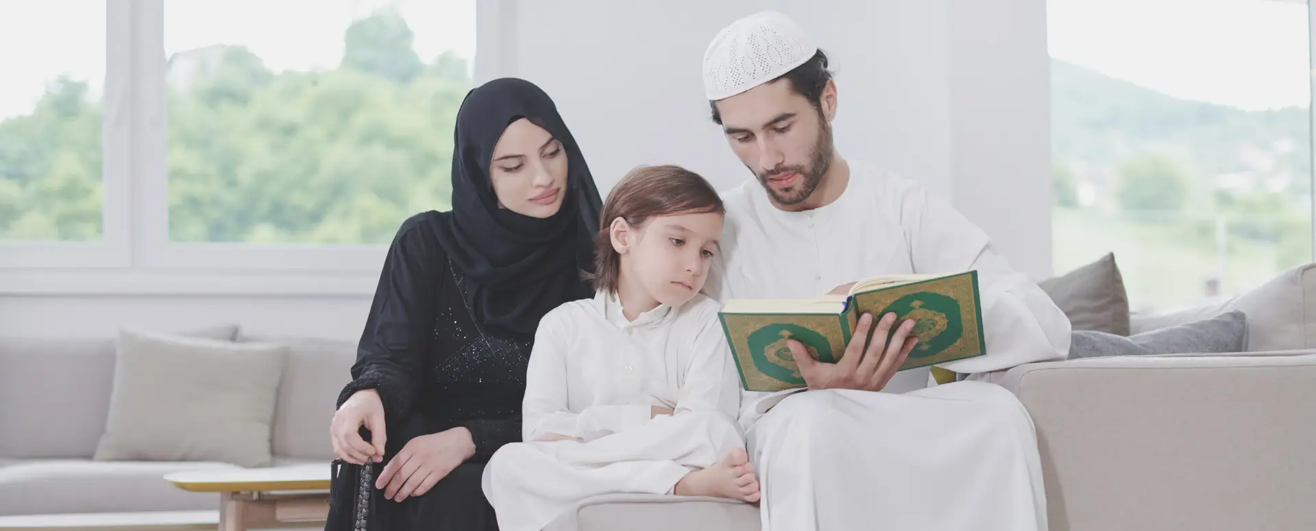 A family of three relaxes on the couch, enjoying story time together in their new home thanks to flexible home loans.