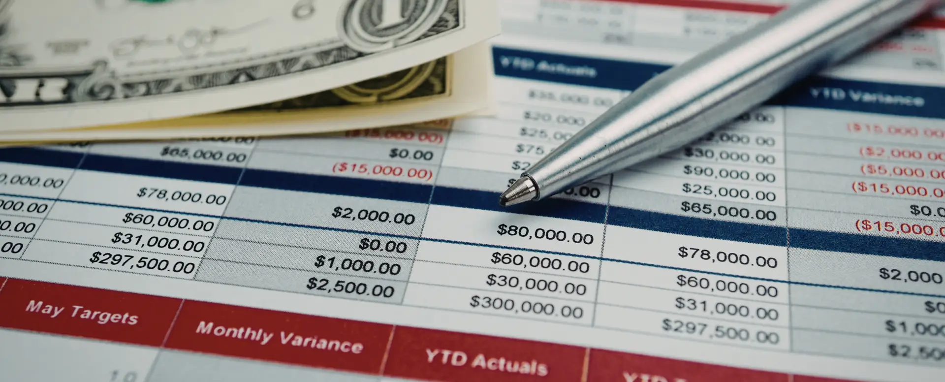 A close-up of a financial spreadsheet with a pen and cash, perfect for first-time home buyers planning purchase home loans.
