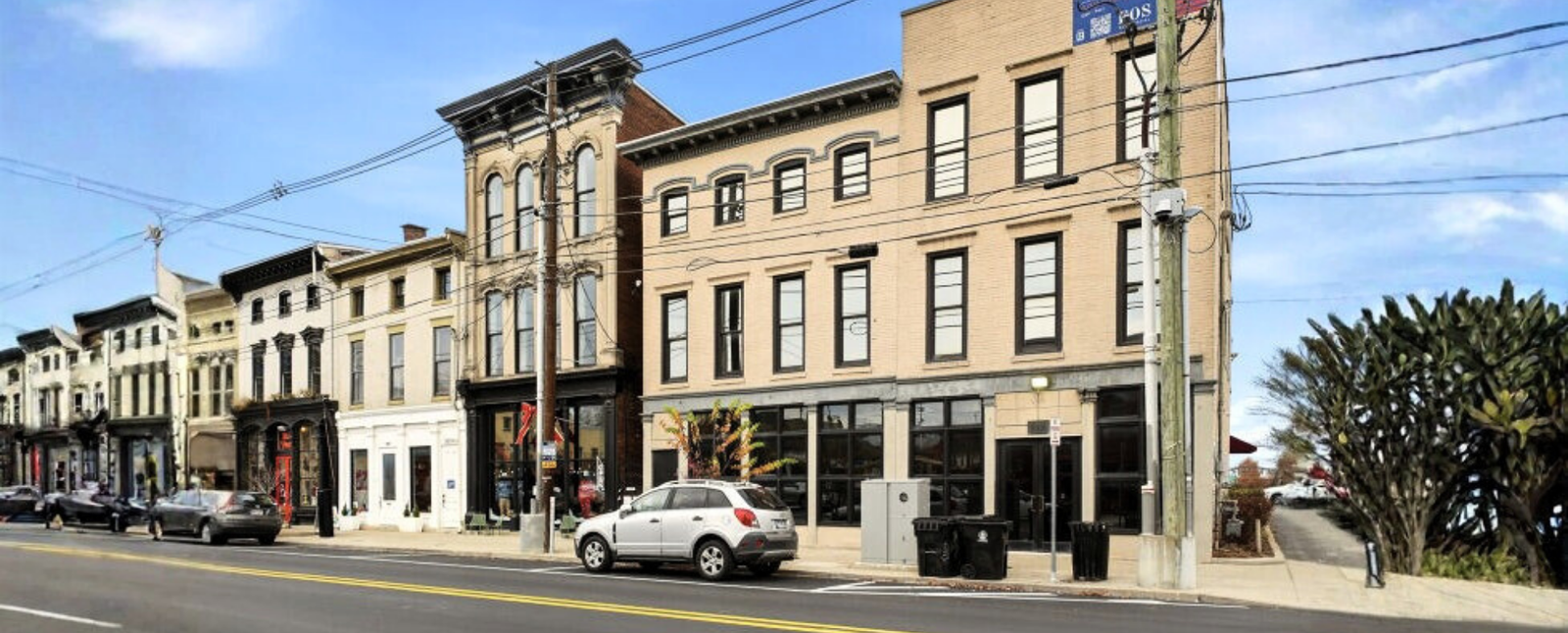 A row of historic brick buildings and shops invites first-time home buyers seeking purchase home loans under a blue sky.